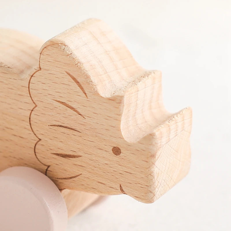 Juguete de madera de dinosaurios sobre ruedas